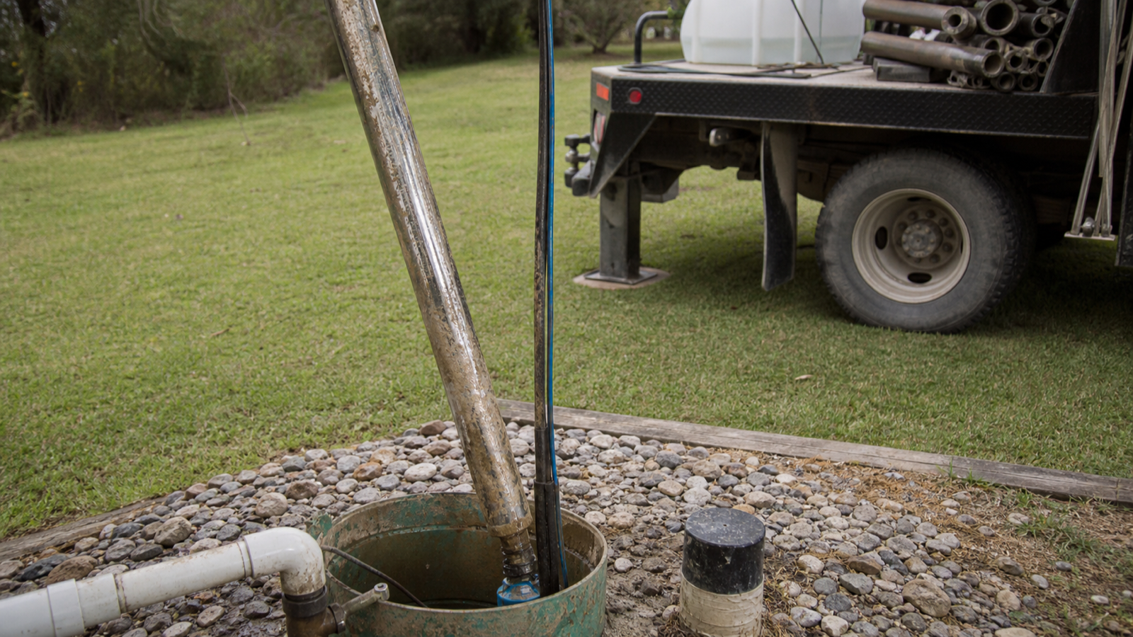 Long run of drop pipe and pump wire being handled during a deep-well pump replacement