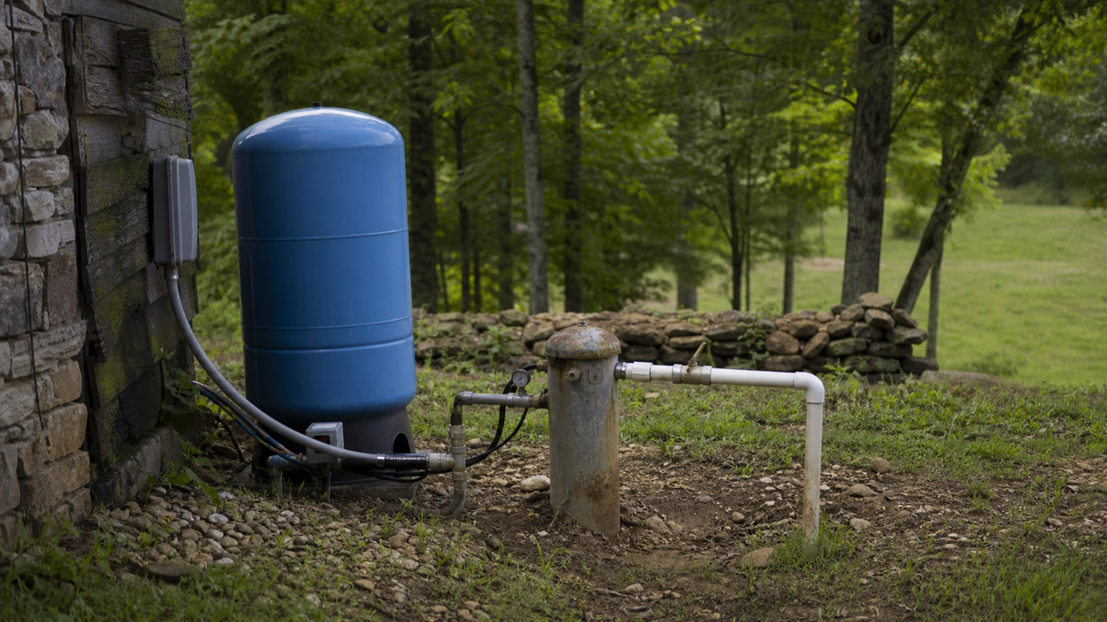 A well head and pressure tank at an established rural Upper Cumberland home